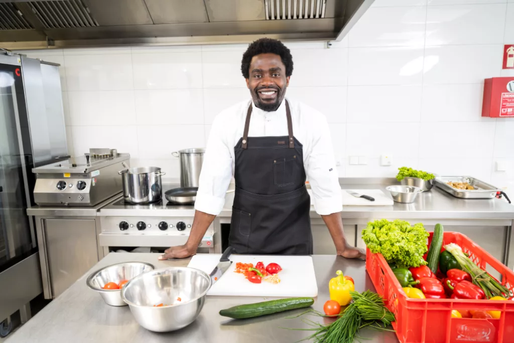Ein Koch stützt sich mit beiden Händen auf eine Arbeitsfläche.