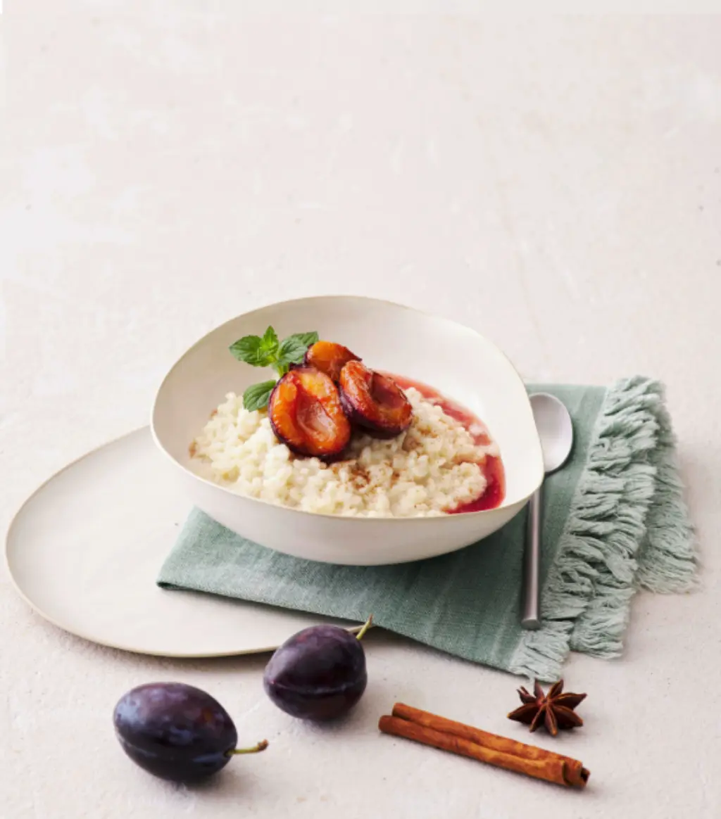 Ein Teller mit Milchreis und eingekochten Pflaumen.