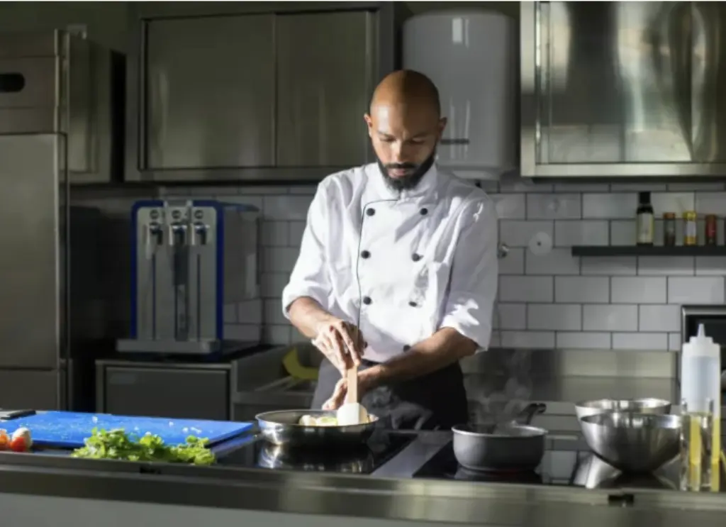 Ein Koch steht in der Küche bei der Arbeit.
