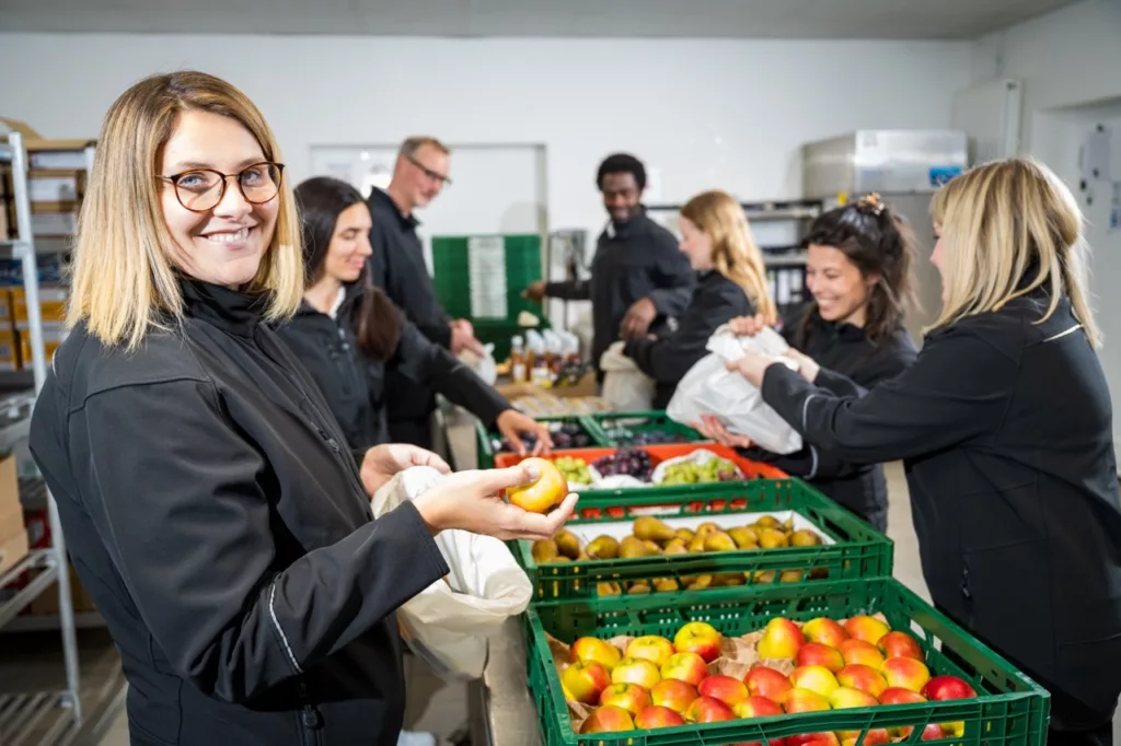 Mitarbeitende arbeiten gemeinsam in einem Lager.