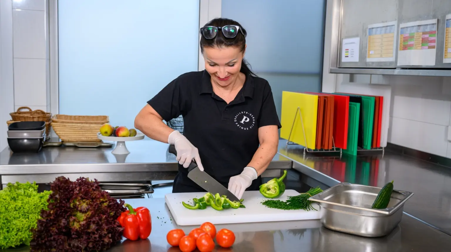 Frau schneidet Gemüse als Servicekraft bei Primus