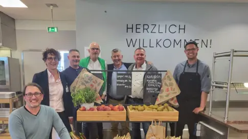 Mehrere Mitarbeiter von Grünenthal stehen vor einer Auswahl frischer Gemüsessorten
