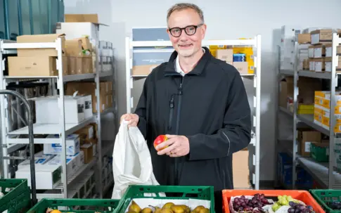 mann_befuellt_tuete_mit_apfel